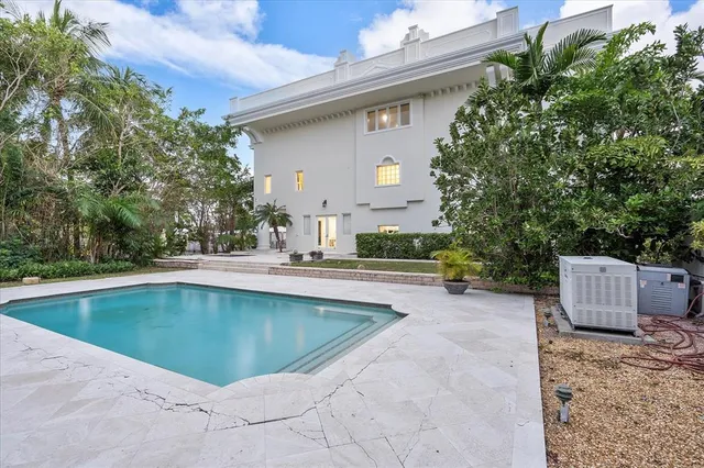 a front view of a house with garden and trees