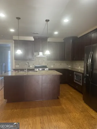 a large kitchen with kitchen island a sink stainless steel appliances and a fireplace
