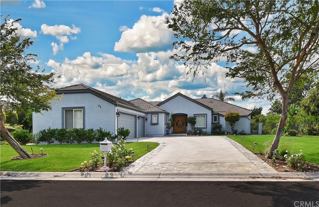 a view of house with a yard and potted plants