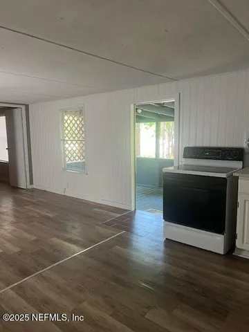 a view of an empty room with a fireplace and a window