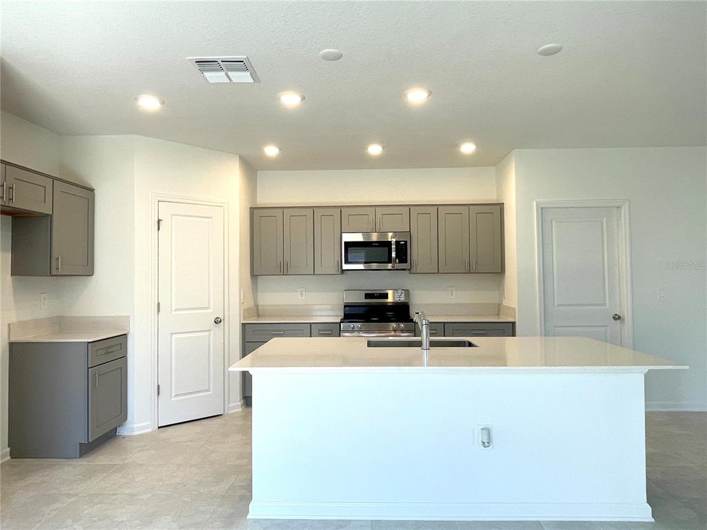 1784 Foreman Road Eagle Lake, FL 33839 - Photo 7 of 24 a kitchen with kitchen island sink stainless steel appliances and cabinets