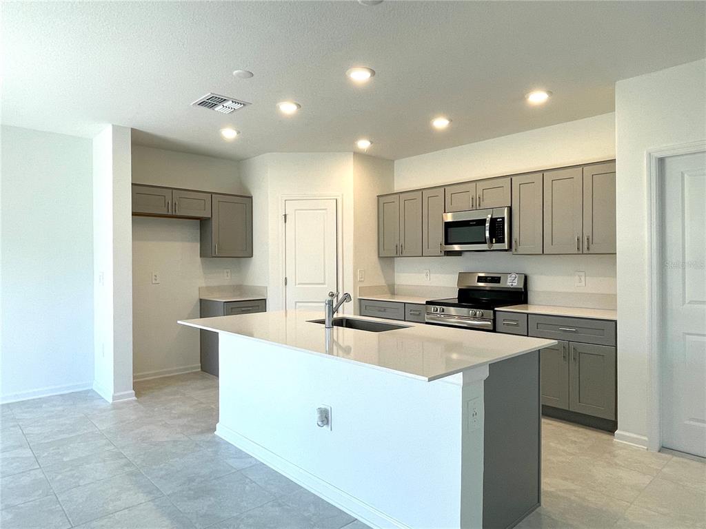 1784 Foreman Road Eagle Lake, FL 33839 - Photo 8 of 24 a kitchen with kitchen island a sink stainless steel appliances and cabinets