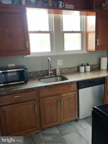 a kitchen with stainless steel appliances granite countertop a sink a stove and a microwave