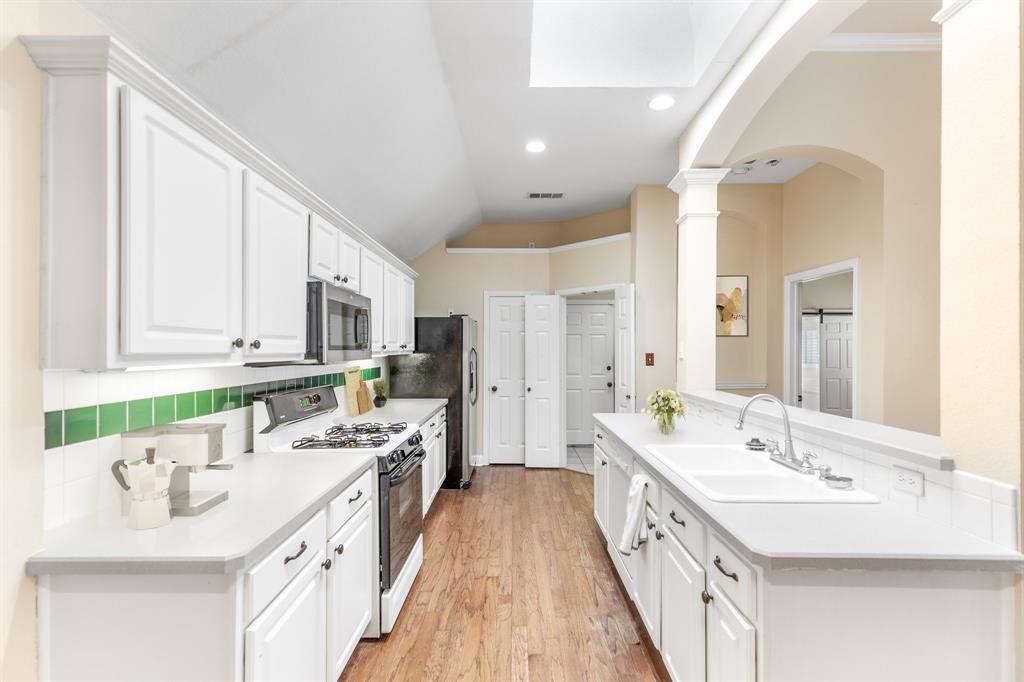 8013 Springmoss Drive Plano, TX 75025 - Photo 8 of 23 a bathroom with a double vanity sink a mirror and a bathtub