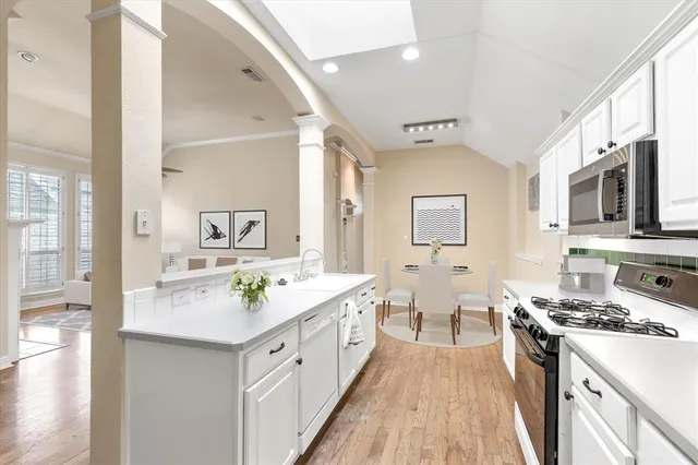 a spacious kitchen with stainless steel appliances granite countertop a lot of counter space and wooden floors