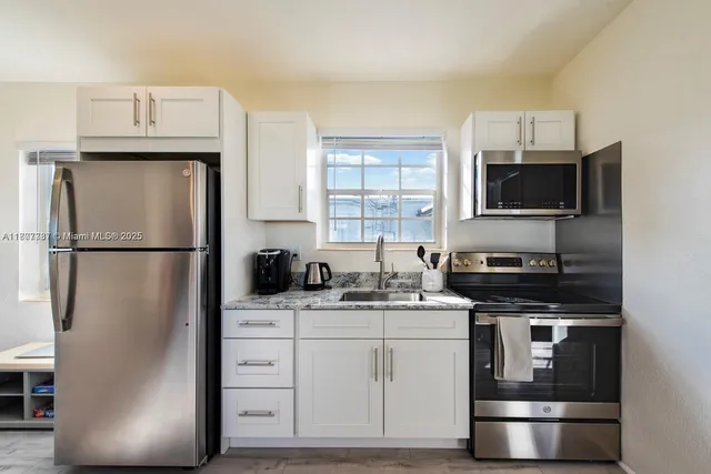 a kitchen with stainless steel appliances a refrigerator stove and microwave