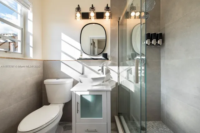 a bathroom with a toilet sink and mirror