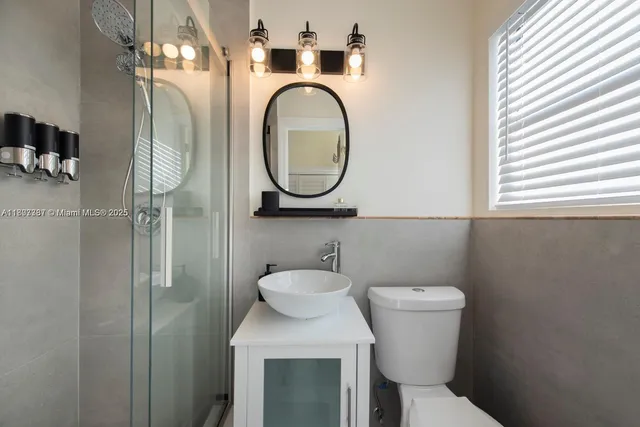 a bathroom with a toilet sink and mirror
