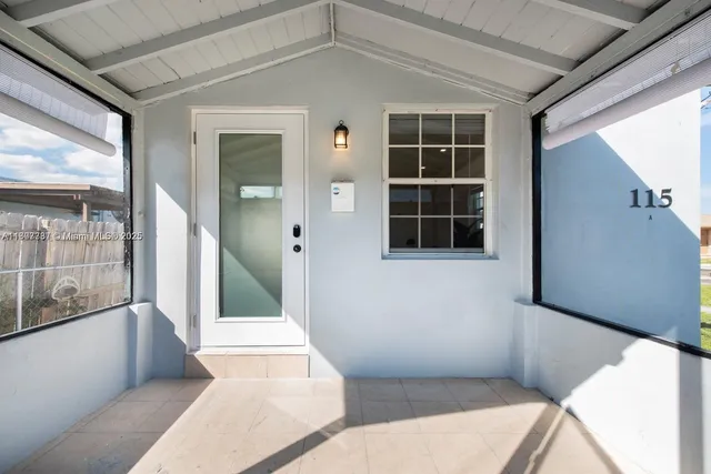 a view of a hallway with wooden floor and windows