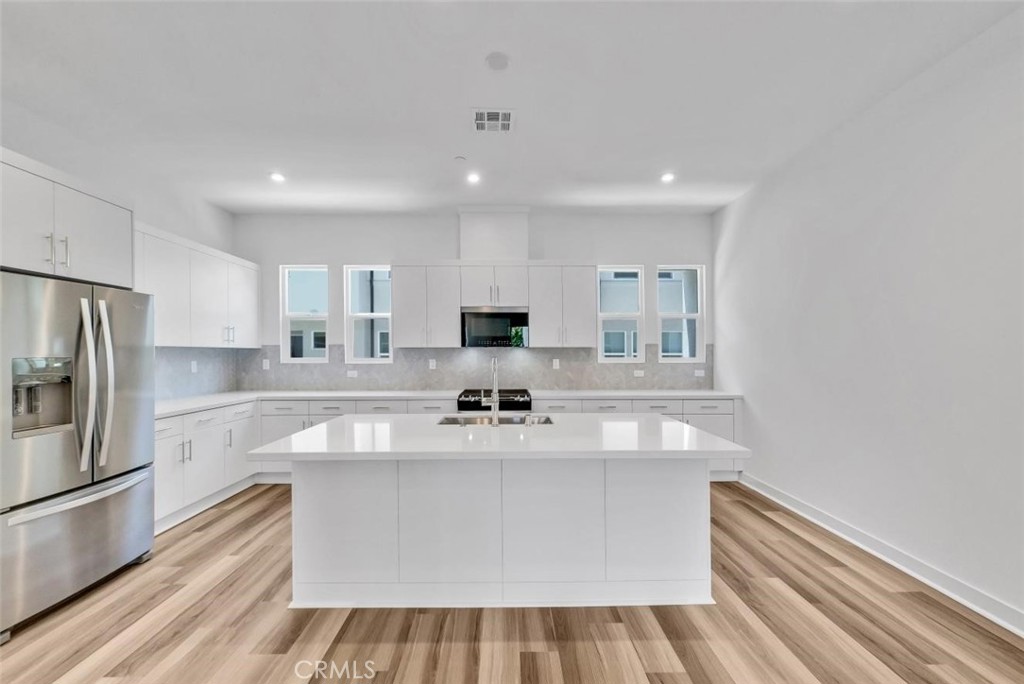 1122 West Bushell Street Anaheim, CA 92805 - Photo 9 of 17 a view of kitchen with center island wooden floor and stainless steel appliances