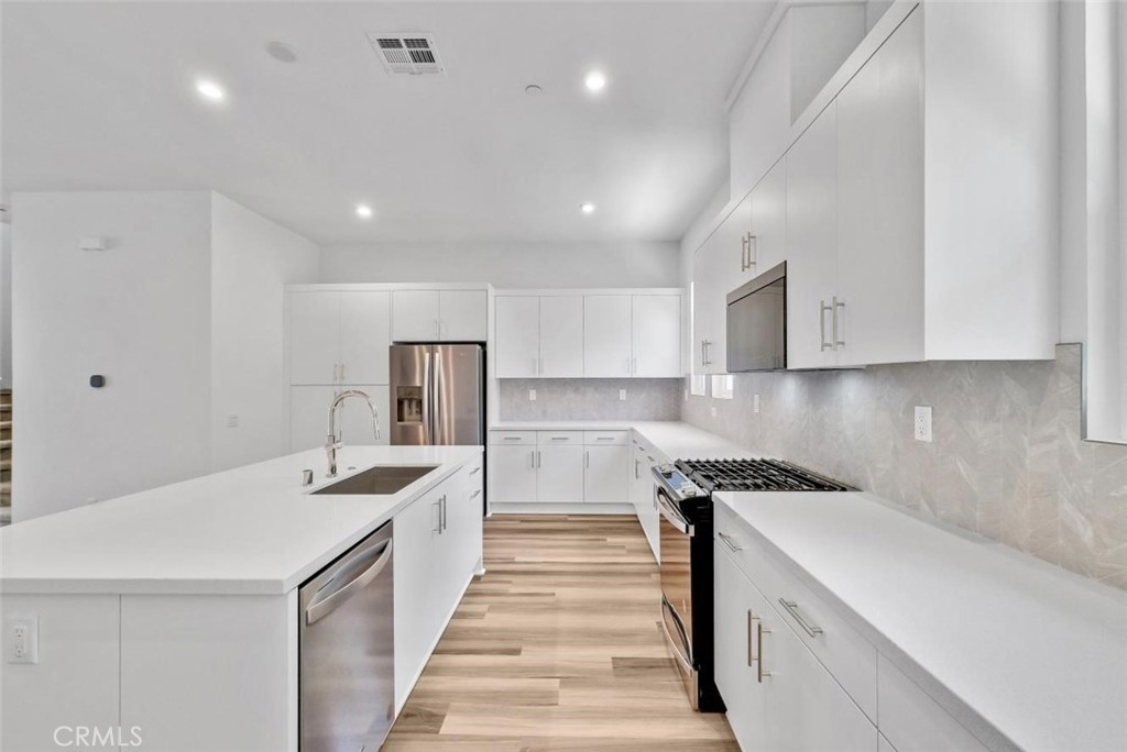 1122 West Bushell Street Anaheim, CA 92805 - Photo 10 of 17 a kitchen with a sink stove and cabinets