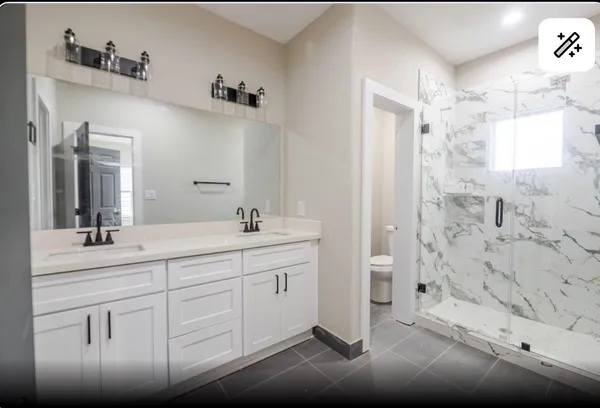 a bathroom with a double vanity sink mirror and shower