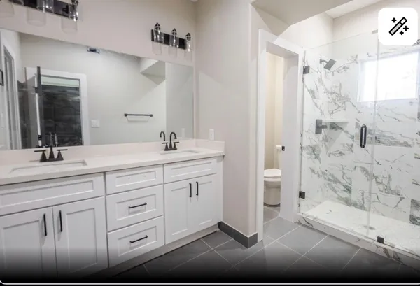 a bathroom with a double vanity sink mirror and shower