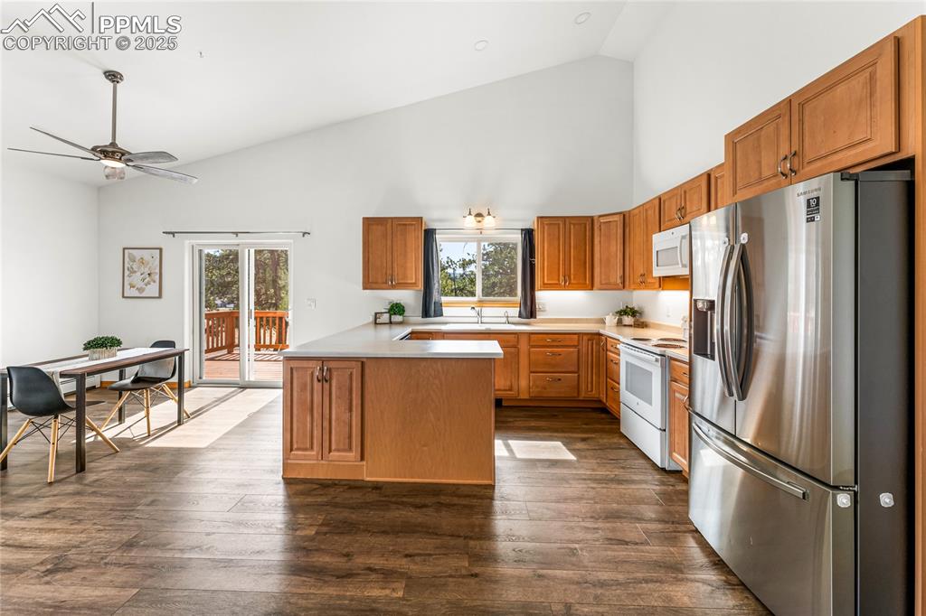 2649 Southpark Road Florissant, CO 80816 - Photo 11 of 42 a kitchen with stainless steel appliances a refrigerator a stove a sink dishwasher a dining table and chairs with wooden floor