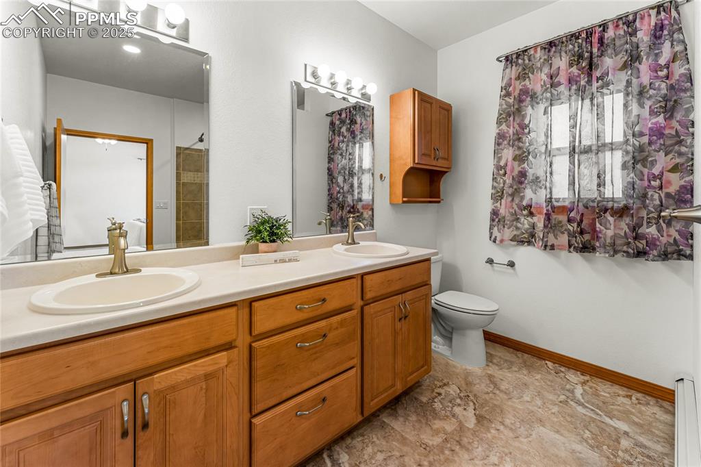 2649 Southpark Road Florissant, CO 80816 - Photo 24 of 42 a bathroom with a double vanity sink mirror and toilet