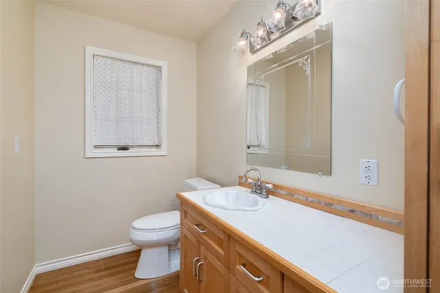 a bathroom with a toilet sink vanity and mirror