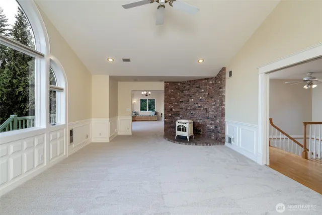 a view of an empty room with fireplace and windows