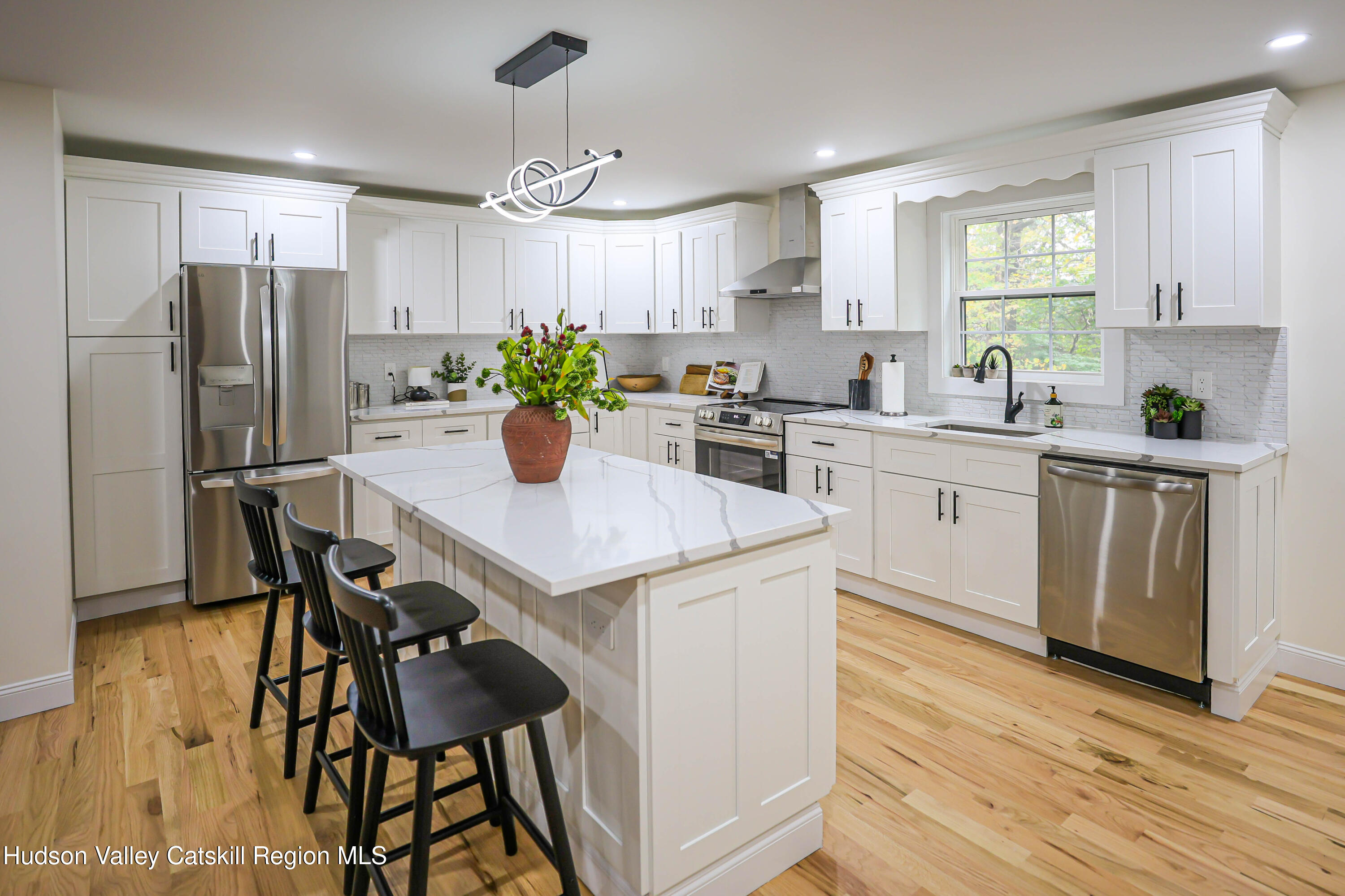 169 West Saugerties Road Saugerties, NY 12477 - Photo 15 of 43 a kitchen with stainless steel appliances a dining table chairs refrigerator and cabinets