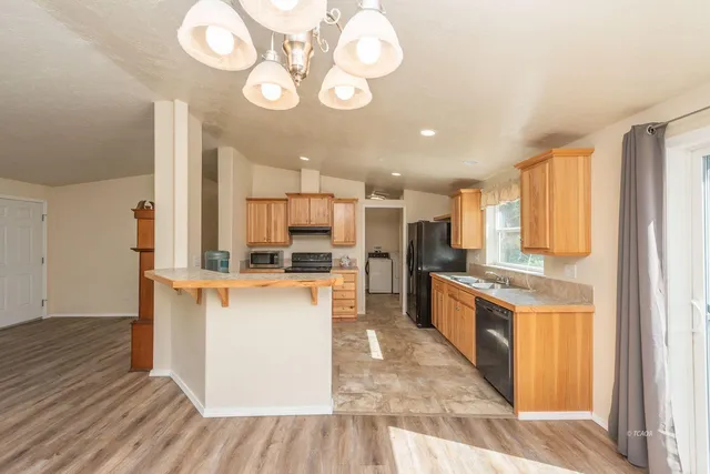 a kitchen with stainless steel appliances a stove top oven a refrigerator a sink and dishwasher