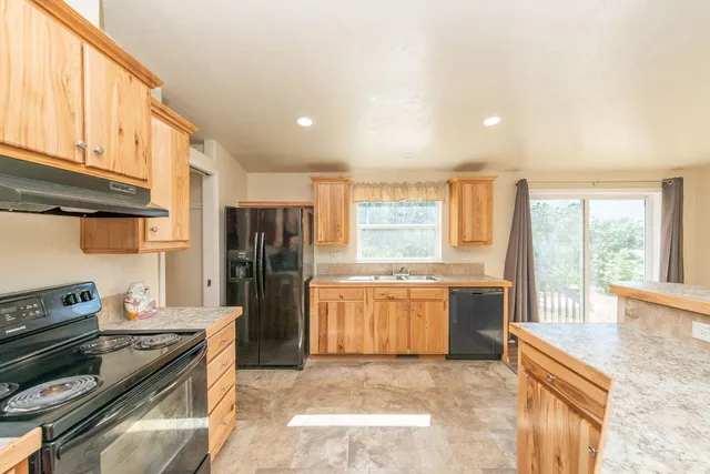 a kitchen with stainless steel appliances granite countertop a stove a sink and a refrigerator