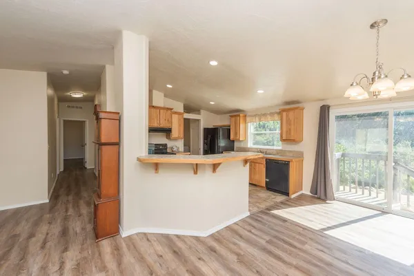 an empty room with wooden floor and a ceiling fan