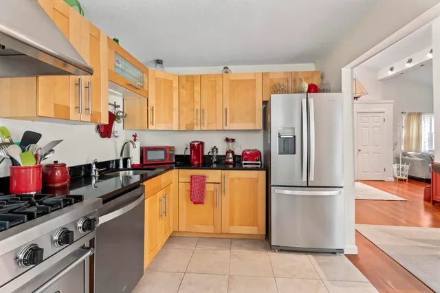 a kitchen with a refrigerator and a stove top oven