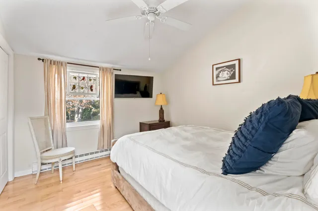 a bed sitting in a bedroom next to a window with a flat screen tv