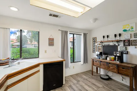 a view of a workspace with furniture and a window