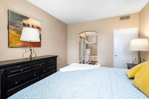 a bedroom with a bed and dresser with mirror