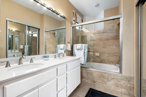 a bathroom with a granite countertop sink mirror and shower