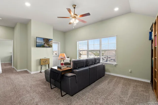 a living room with furniture and a ceiling fan