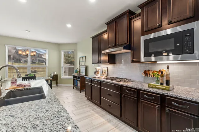 a kitchen with stainless steel appliances granite countertop a stove sink microwave and cabinets