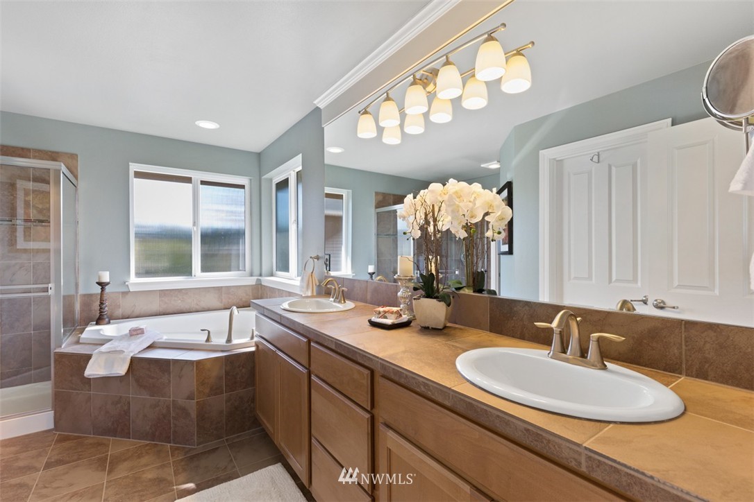 233 Chelan Avenue Northeast Renton, WA 98059 - Photo 12 of 16 a spacious bathroom with a granite countertop sink and a large mirror