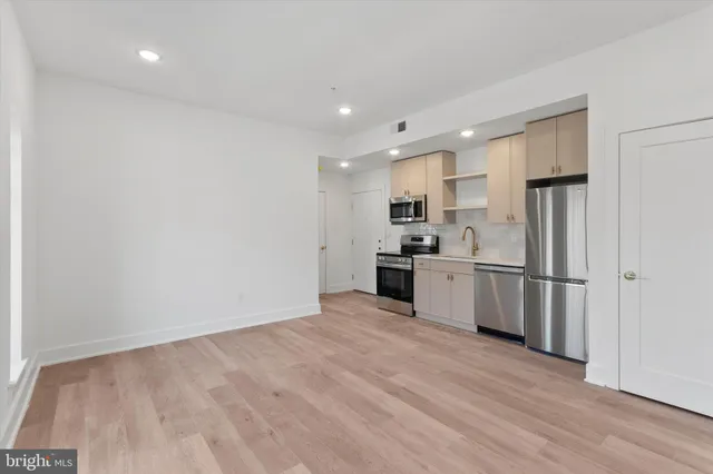 a kitchen with white cabinets and stainless steel appliances
