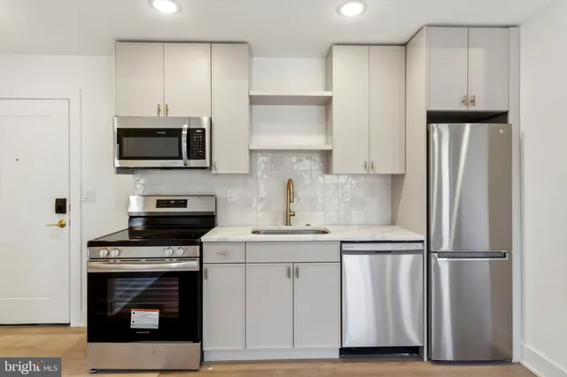 a kitchen with white cabinets and stainless steel appliances