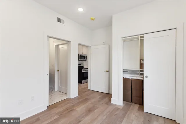 a view of a kitchen with a refrigerator and wooden floor