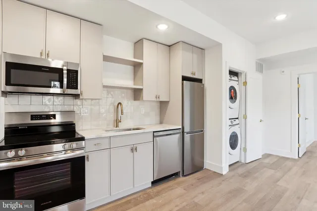 a kitchen with stainless steel appliances white cabinets and a refrigerator
