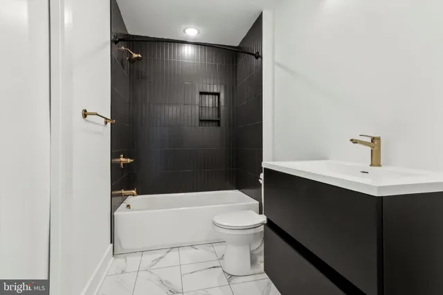 a bathroom with a bathtub shower sink vanity and toilet