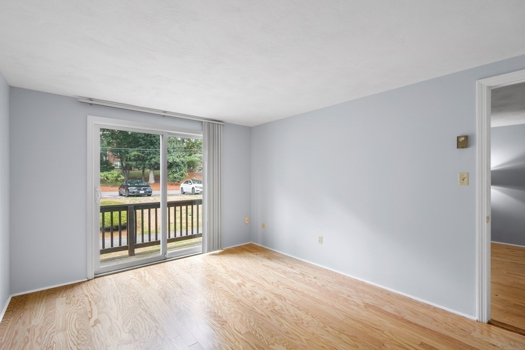 7 Wampus Avenue, Unit 15 Acton, MA 01720 - Photo 14 of 30 a view of an empty room with wooden floor and a window