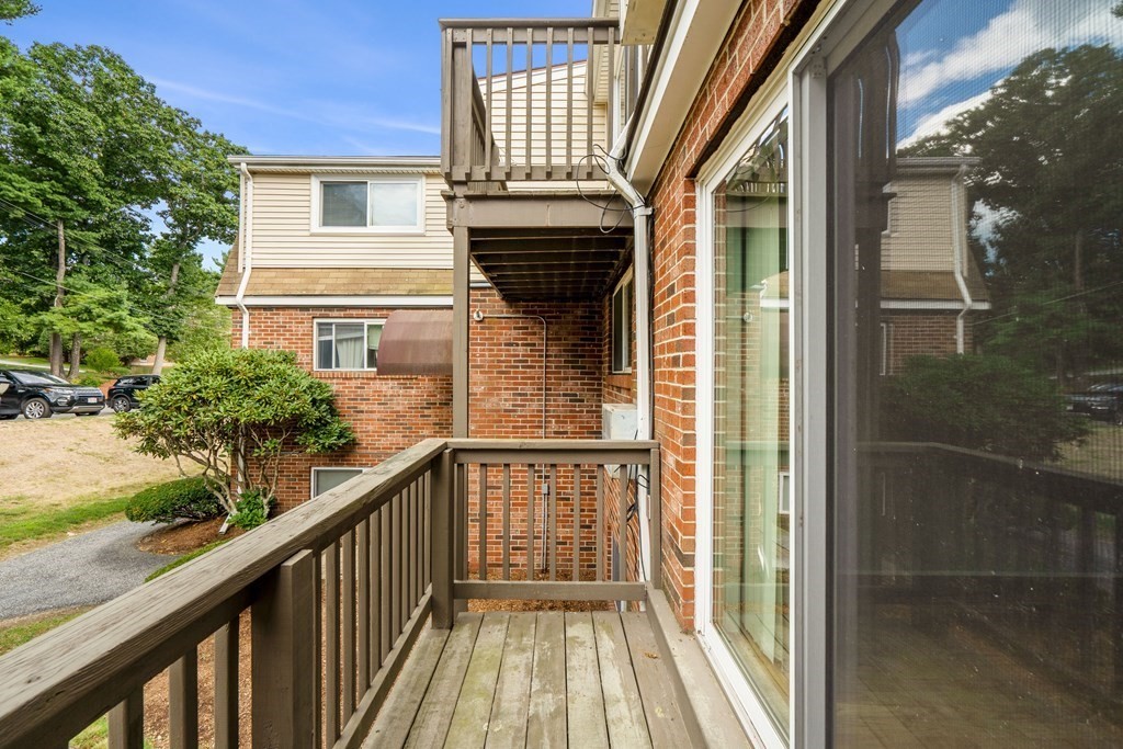 7 Wampus Avenue, Unit 15 Acton, MA 01720 - Photo 20 of 30 a view of a balcony with wooden floor and fence