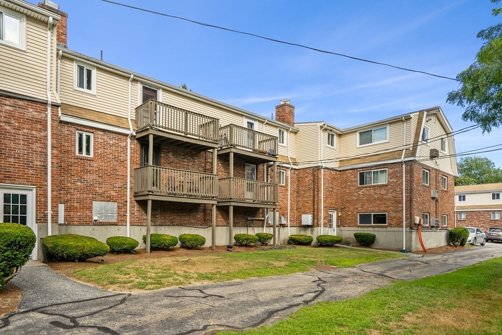 7 Wampus Avenue, Unit 15 Acton, MA 01720 - Photo 26 of 30 a view of a big building with a yard and plants