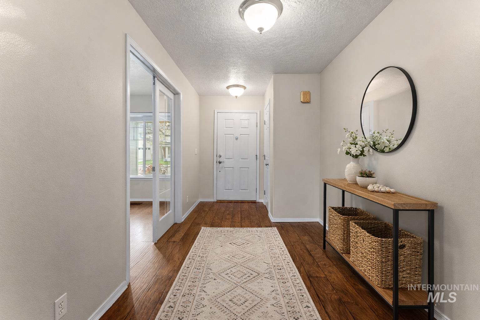 2503 Carnegie Street Caldwell, ID 83607 - Photo 2 of 20 Doorway to outside featuring hardwood / wood-style floors and a textured ceiling