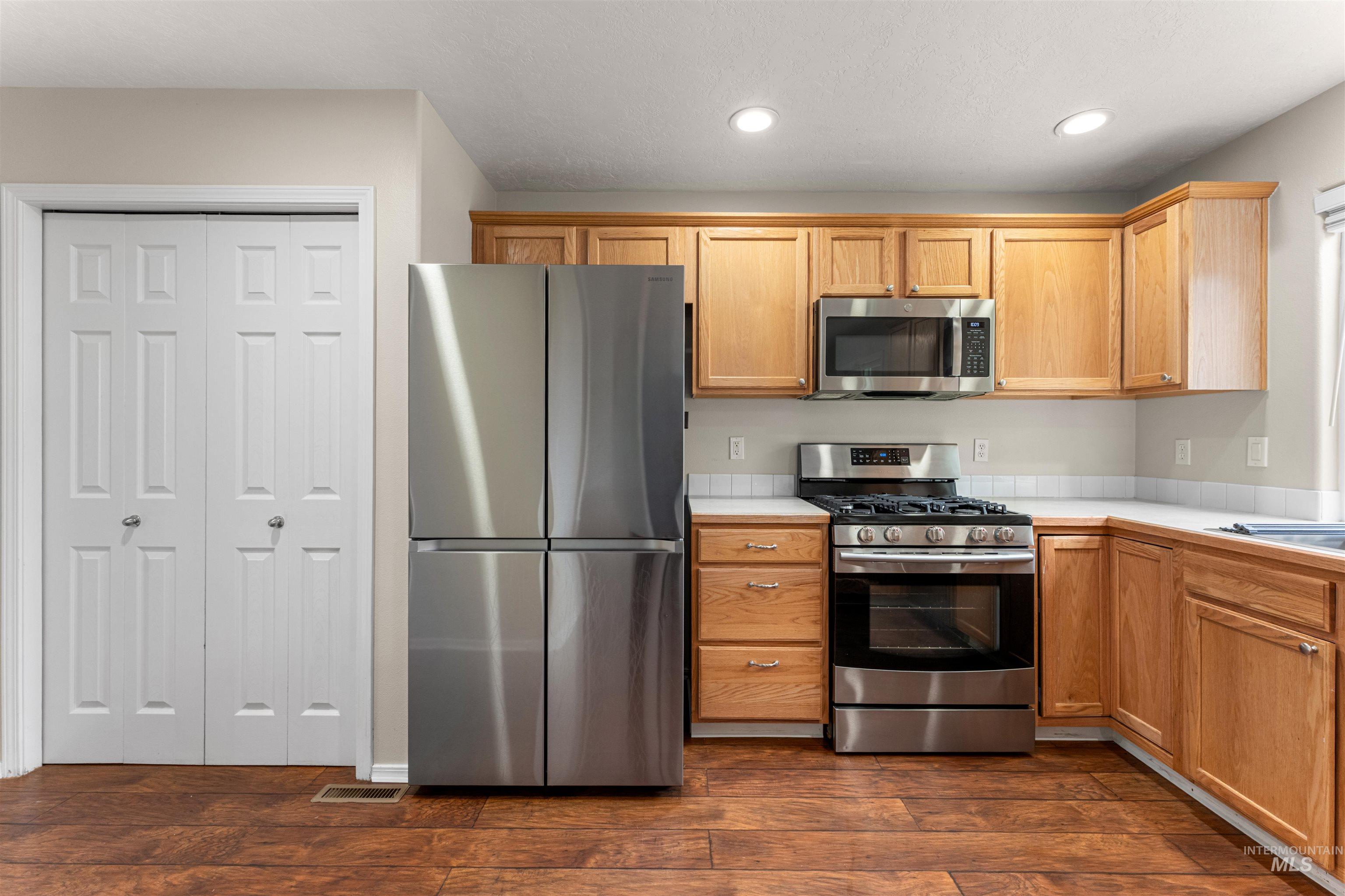 2503 Carnegie Street Caldwell, ID 83607 - Photo 7 of 20 Kitchen with stainless steel appliances, dark wood-style flooring, recessed lighting, and tile counters