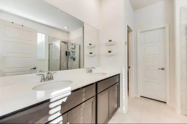 a bathroom with a sink double vanity and a mirror