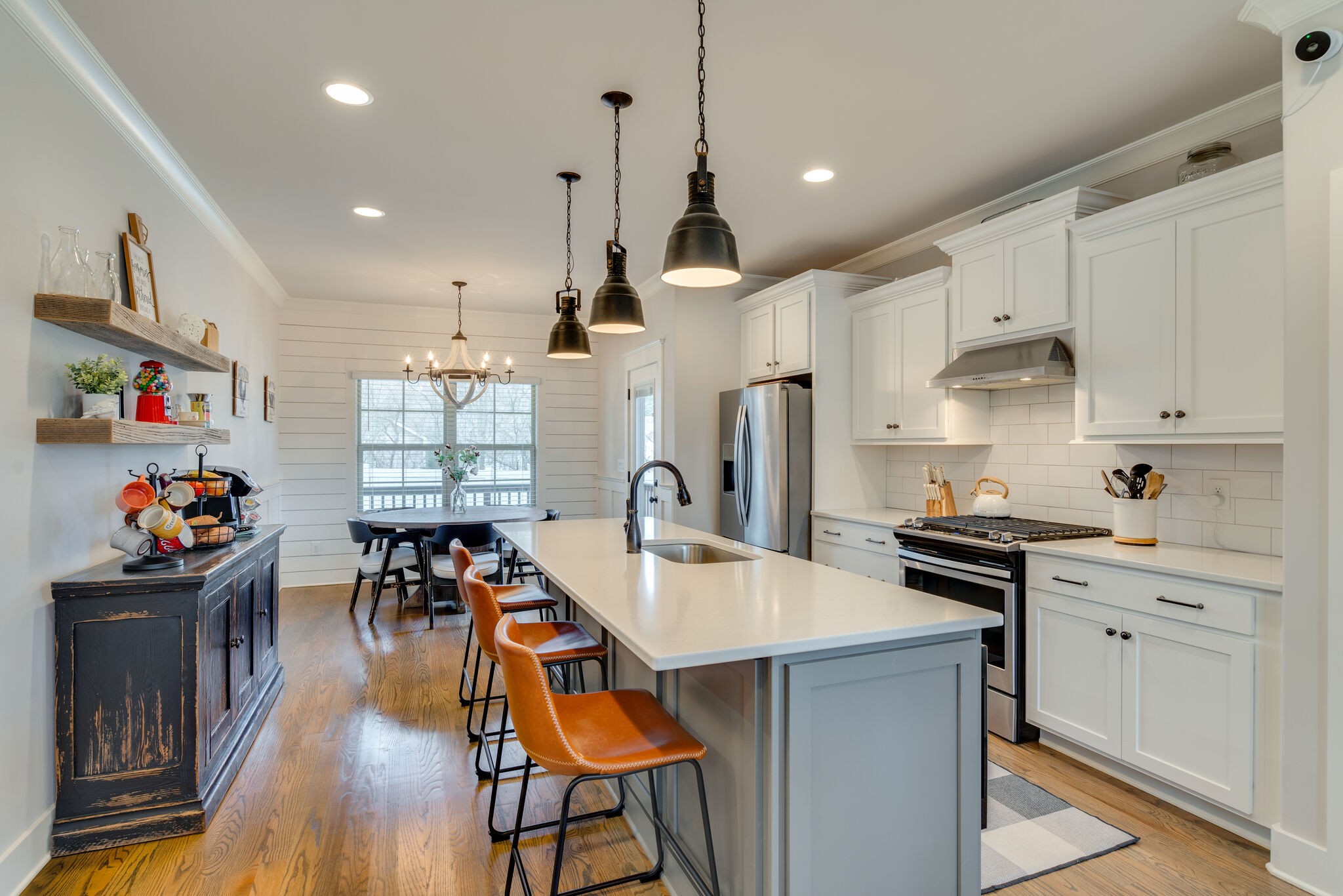987 Carnation Drive Spring Hill, TN 37174 - Photo 6 of 26 a kitchen with stainless steel appliances a stove a sink a kitchen island and chairs with wooden floor