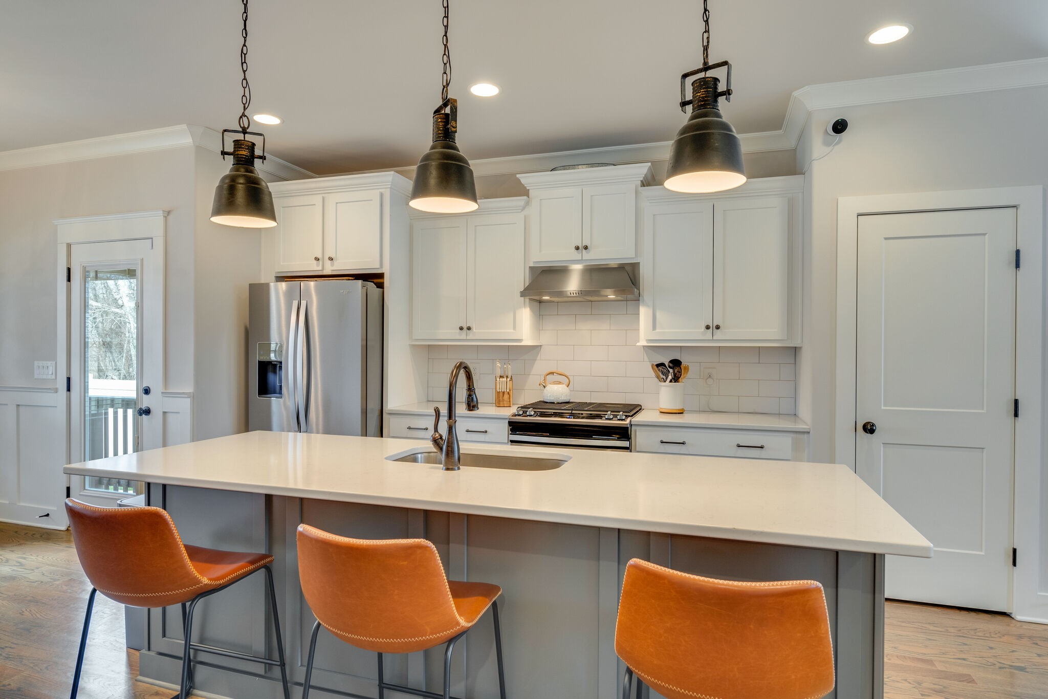 987 Carnation Drive Spring Hill, TN 37174 - Photo 7 of 26 a kitchen with stainless steel appliances a sink a stove a refrigerator and white cabinets with wooden floor