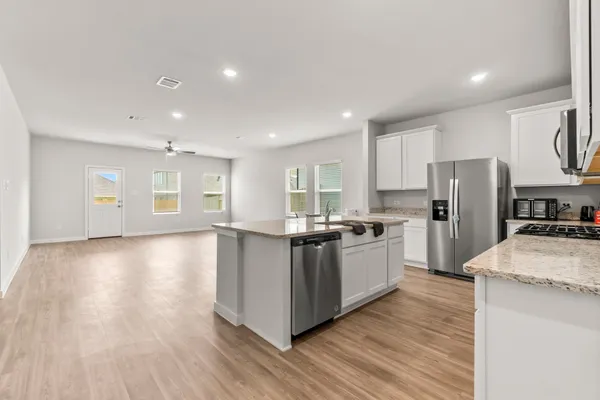 a kitchen with a refrigerator and a stove top oven
