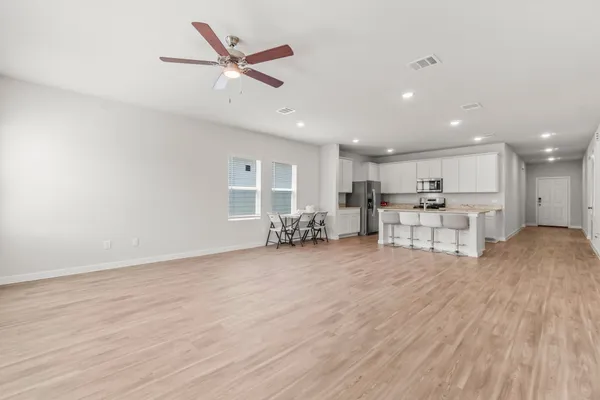 a view of a livingroom with chairs and wooden floor