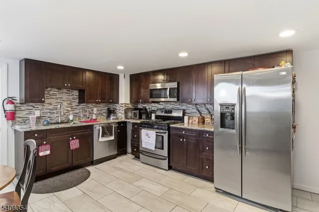 a kitchen with stainless steel appliances granite countertop a refrigerator and a sink
