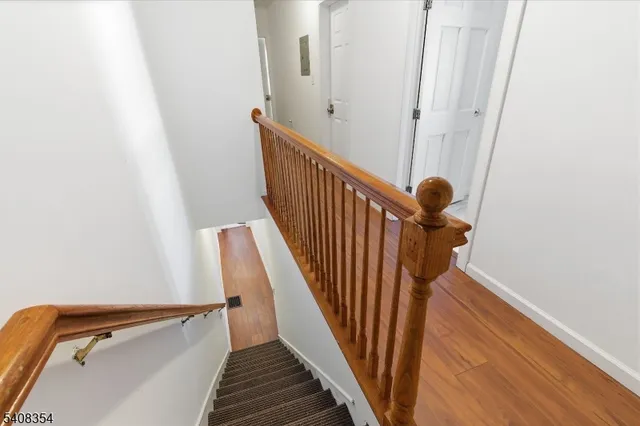 a view of staircase with railing and white walls